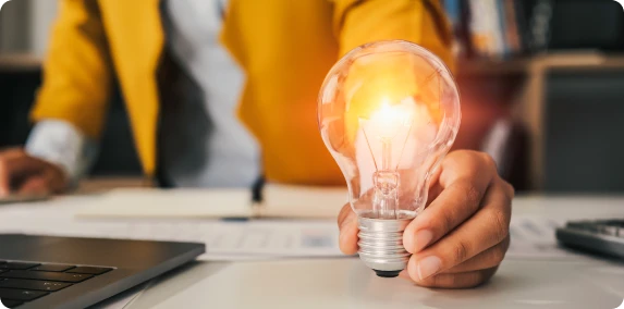 Mão segurando lâmpada.